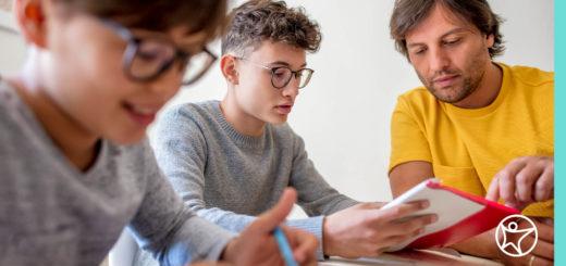 一位父亲正在帮助他的两个儿子做网上作业